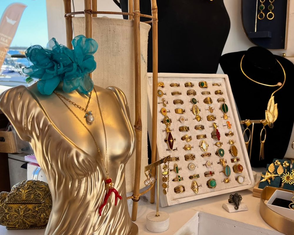 Expositor de anillos y collares junto al maniquí dorado