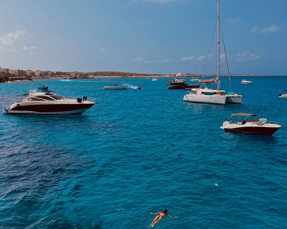 Agua turquesa de Formentera con barcos fondeados